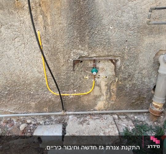 צינור גז מחובר לקיר עם בלון גז ירוק